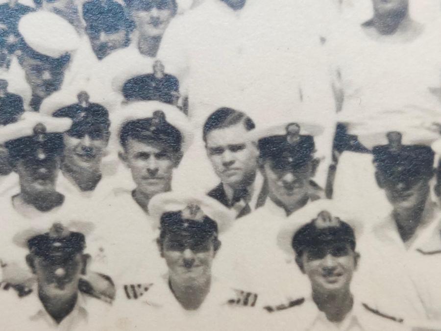 Canteen Assistant Kenneth Rowe, centre, hatless and in civilian clothing with crew of HMAS 'Sydney' II, c. September 1940. Courtesy Brad Manera Collection. 