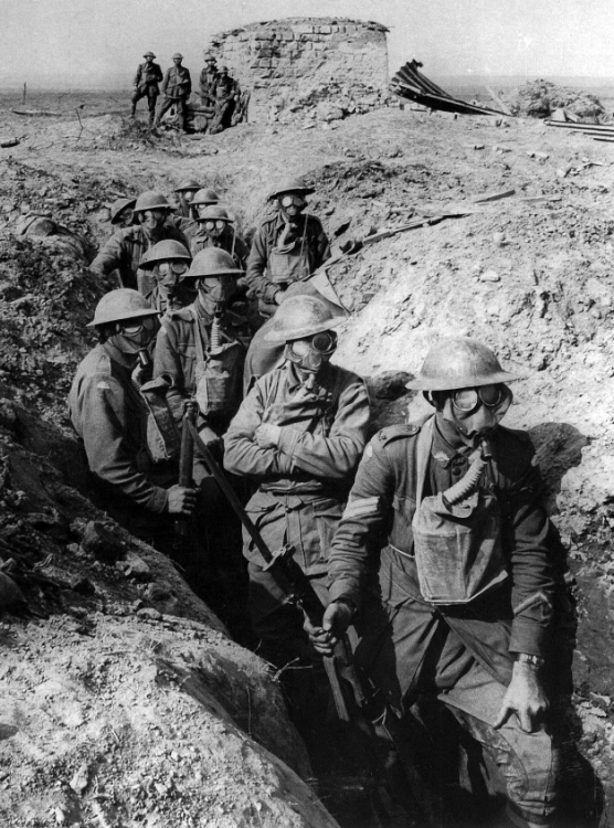 Wearing their box respirators as protection against poison gas, men of the NSW-raised 14th Brigade pose for a photograph by Frank Hurley the day after the capture of Polygon Wood. Note the German pillbox in the background. National Library of Australia. 